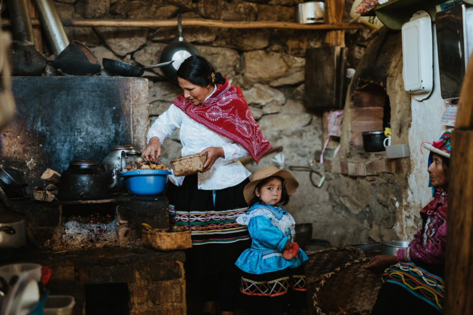 Onze gastvrouw Lucy verdeelt de aardappelen, gegaard in een oven onder de grond. Foto: Björn Snelders